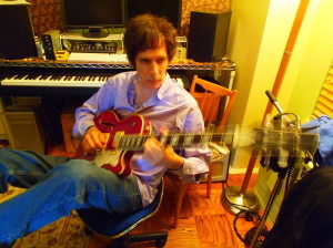 Stickin’ Stone: Heyman composing on his Waterstone guitar in his home studio. Photo by Nancy Leigh.